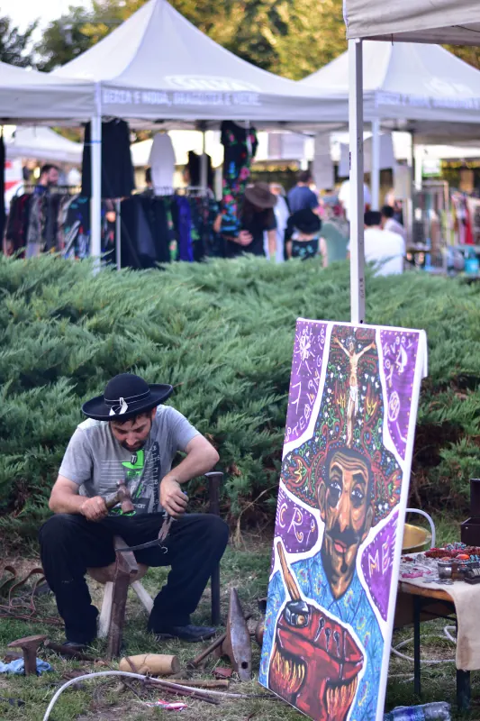 Meșter lângă o pictură colorată inspirată din cultura romă