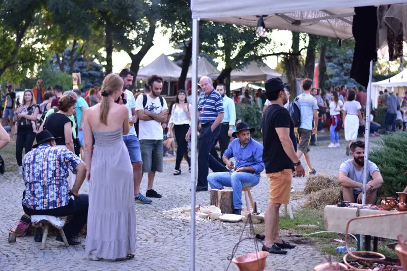 Vizitatori plimbându-se printre meșterii la lucru