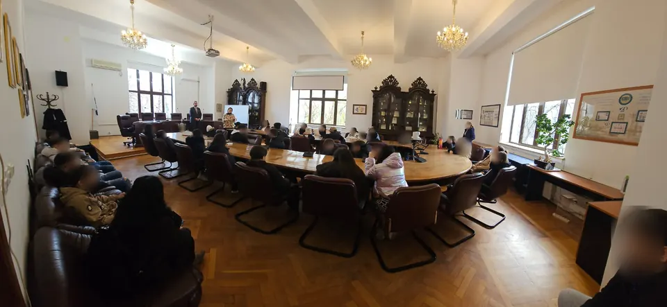 Elevii în sala de consiliu, cu mobilier de epocă și candelabre