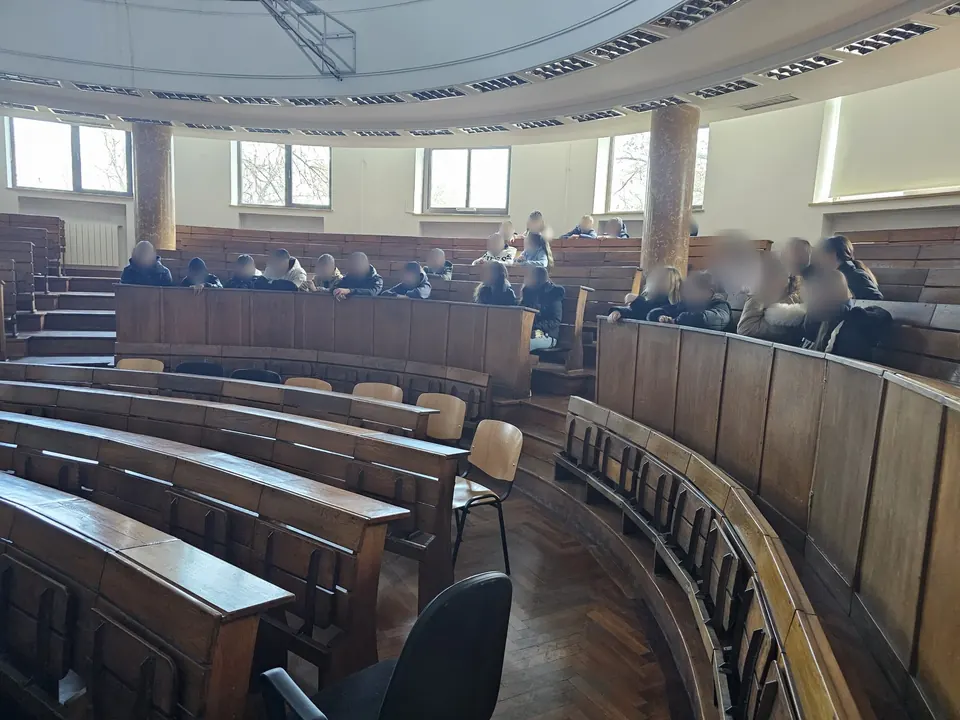Elevi urmărind explicațiile din băncile amfiteatrului