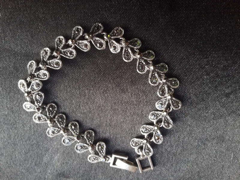 Silver bracelet with floral motifs on a dark background